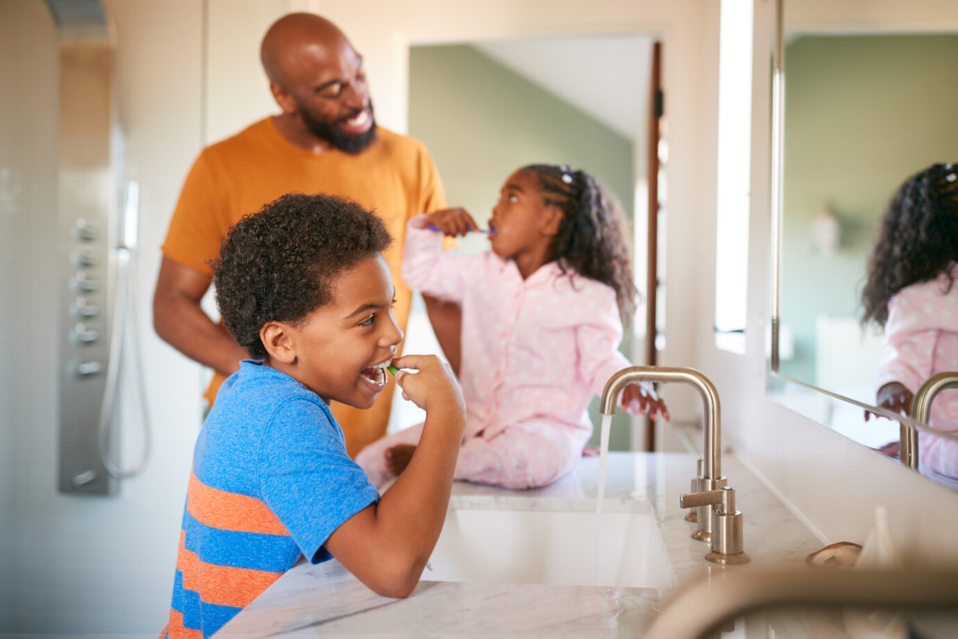 Parent teaching children to brush their teeth properly.